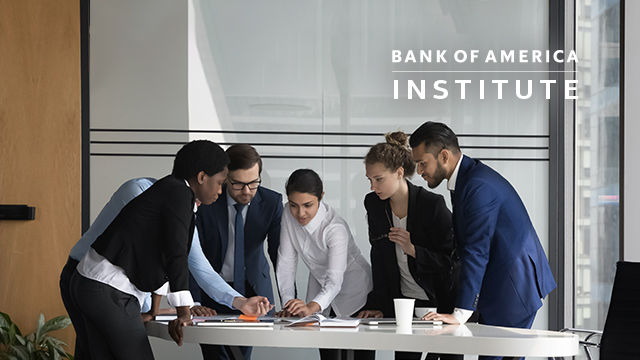 Diverse business group meeting at a table in a modern office space.